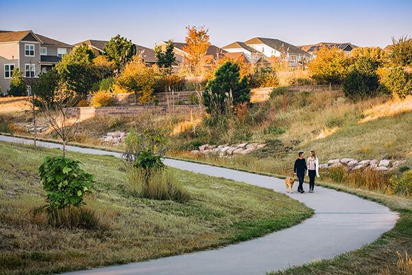 Two residents walking their dog on one of the outdoor trails in Inspiration.