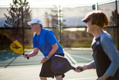 Residents playing pickleball in Hilltop at Inspiration 55+ Community in Parker CO